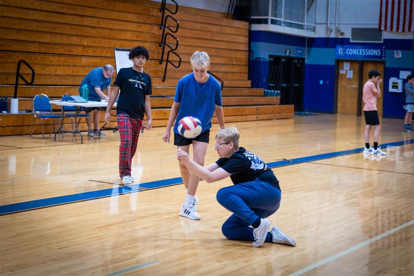 Students play volleyball in PE